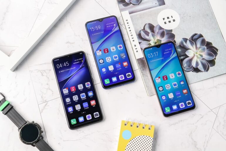 Três smartphones Vivo Y5s sobre uma bancada com outros itens.