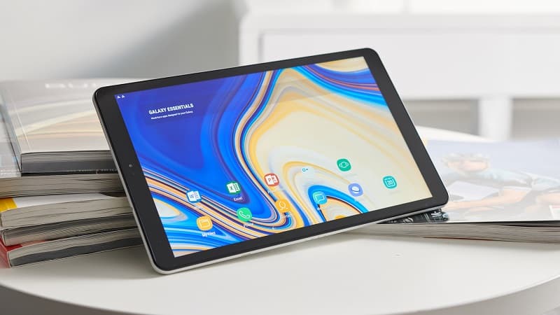 Samsung Galaxy Tab A 10.5 com a tela ligada, sobre algumas revistas.