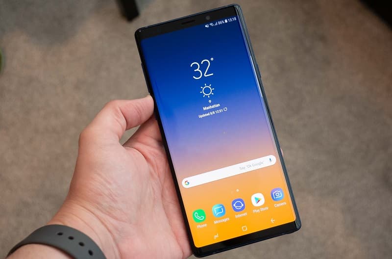 Galaxy Note 9 sendo segurado com a tela ligada.