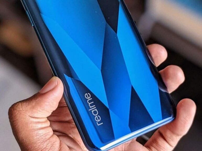 Foto com foco no logo da Realme na traseira de um smartphone na cor azul.