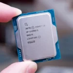 Foto do processador Intel Core i9-14900KS sendo segurado pelas bordas entre os dedos indicador e polegar de uma pessoa.